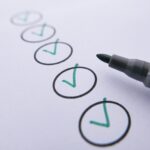 Checklist with multiple green check marks circled in black, marker pen at the edge suggesting tasks completed.